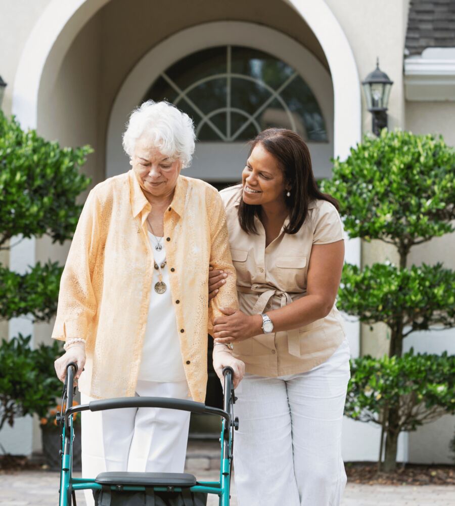 A nurse supporting an older patient at home