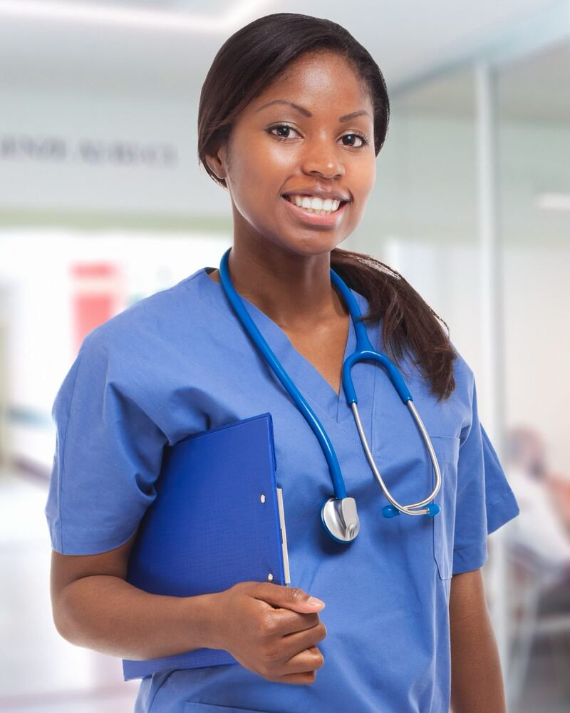 A smiling nurse holding a clipboard