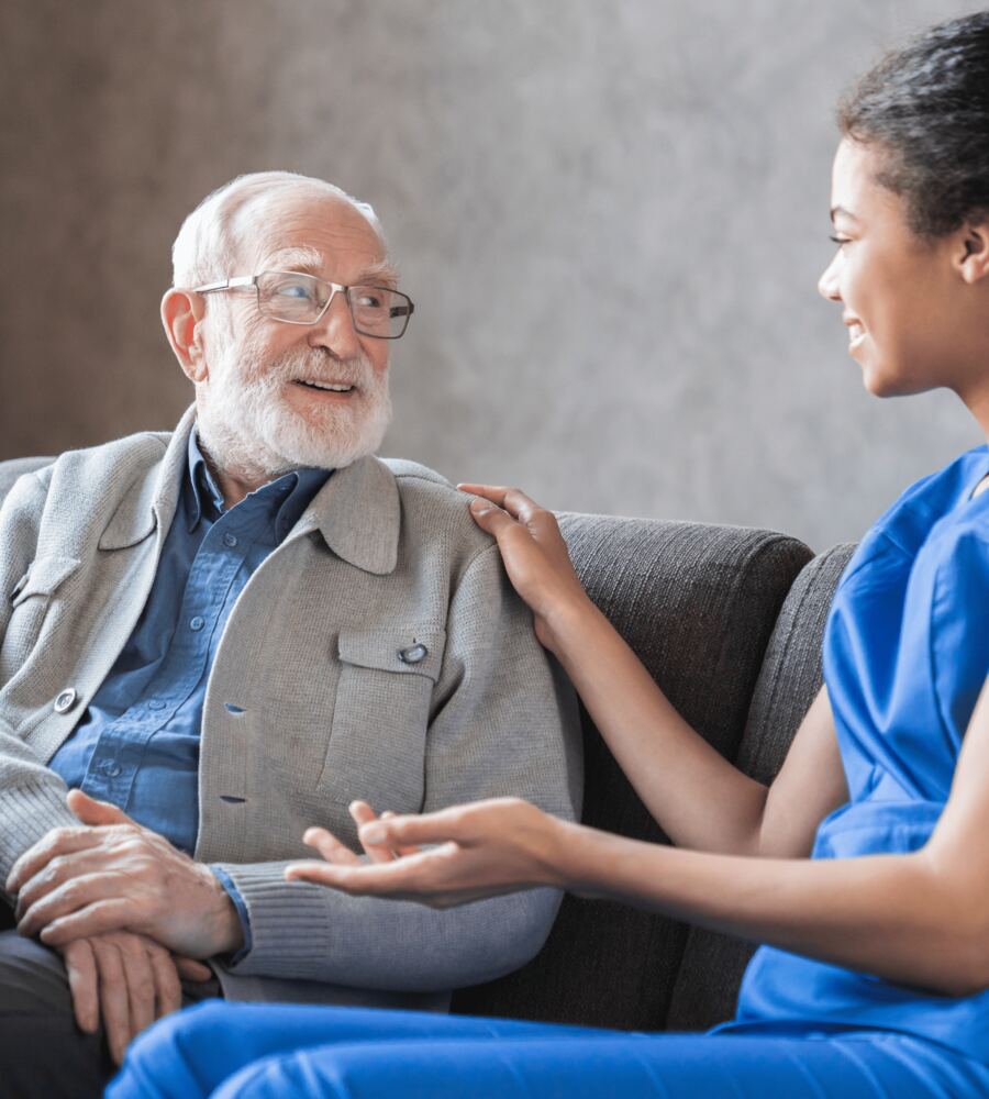 A caregiver helping an older man stand up safely